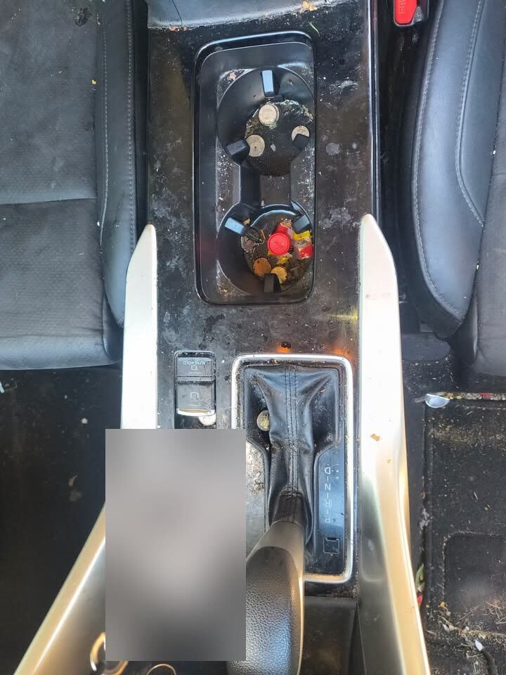 Before: Mitsubishi SUV center console and cup holders full of grime and debris before a Gleam Team interior detail in Charlotte and Raleigh NC